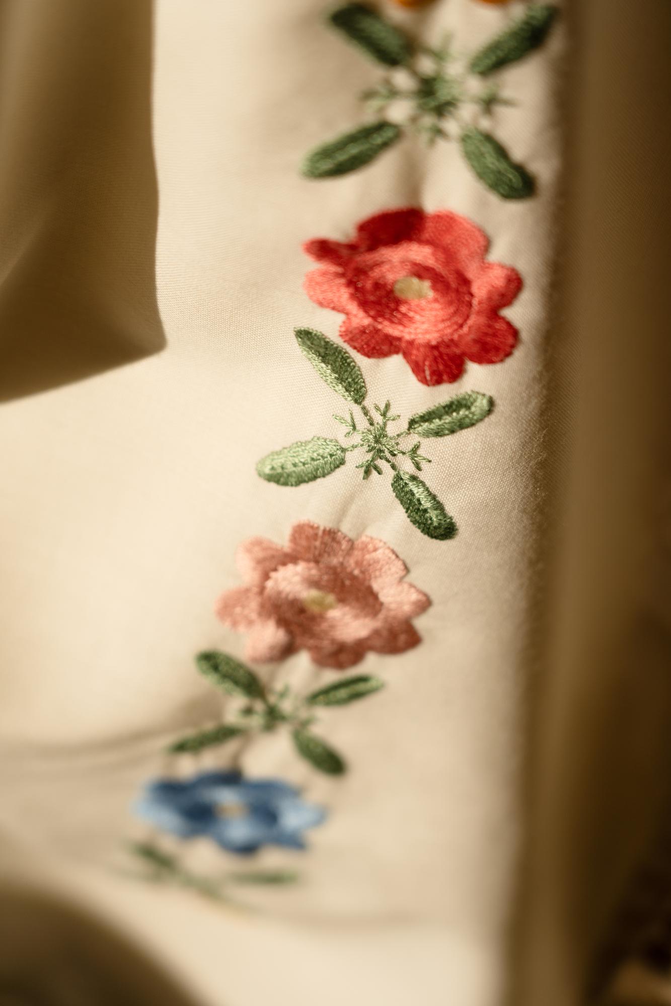Close-up of hand-stitched floral embroidery on linen